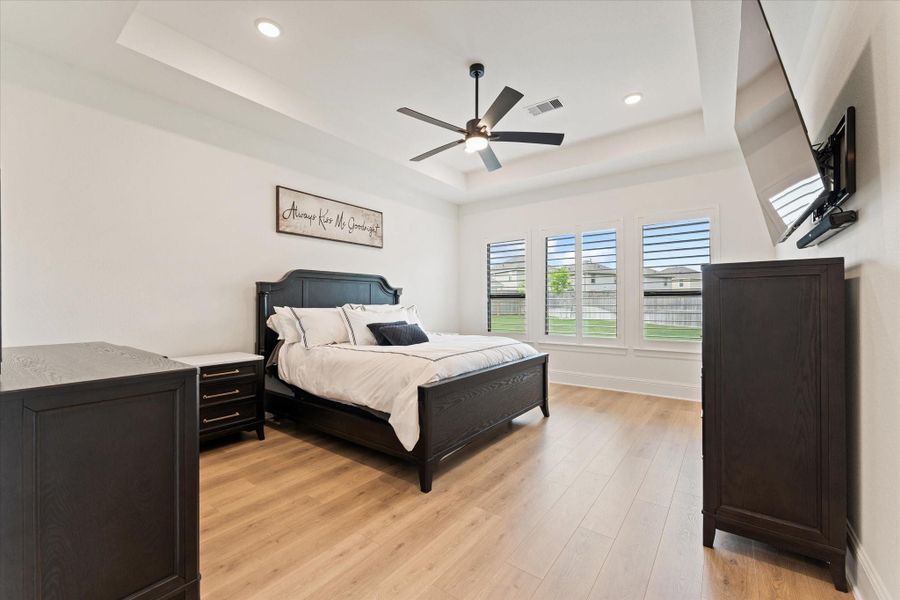 The spacious primary suite offers a serene retreat with elegant finishes, soft natural lighting, and a calming neutral palette. Designed for comfort and relaxation, this private escape creates the perfect atmosphere to unwind at the end of the day.