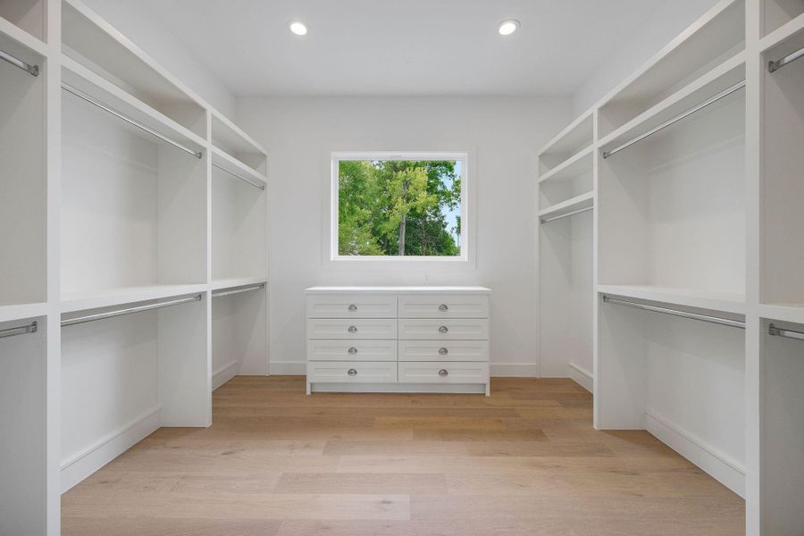 Generous primary closet with beautiful natural light streaming in and tree-top views. Generous primary closet with beautiful natural light streaming in and tree-top views.
