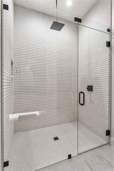 Bathroom with a stall shower and concrete floors