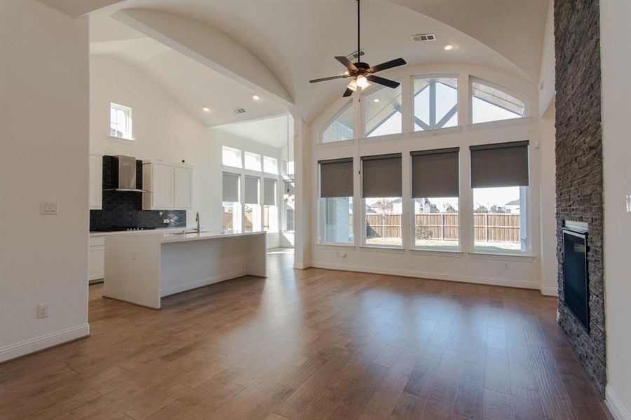 living room featuring hardwood / wood-style flooring, a stone fireplace, and a wealth of natural light