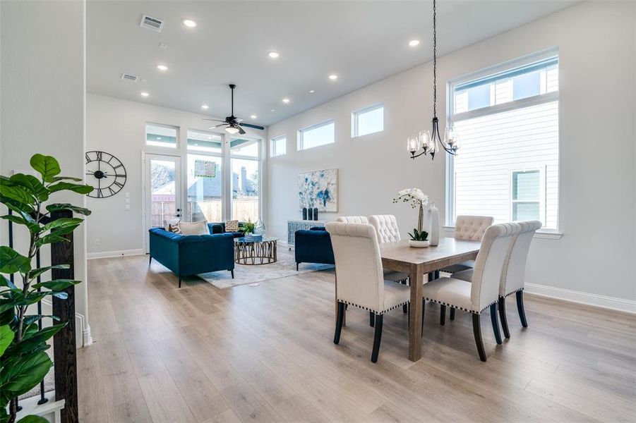 Dining room featuring light hardwood / wood-style floors and ceiling fan with notable chandelier