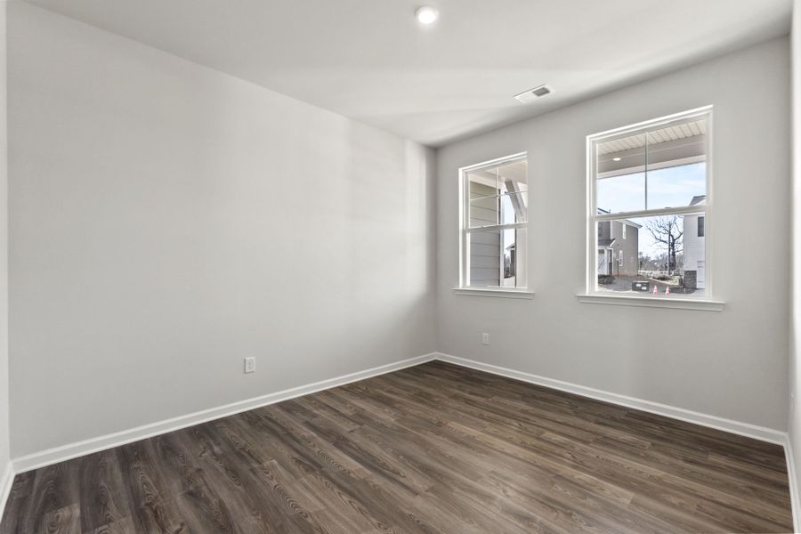 A room with a wood floor and windows.