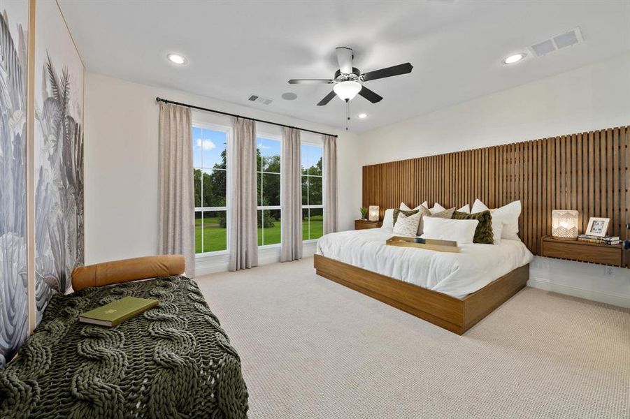 Main bedroom with ceiling fan and light colored carpet