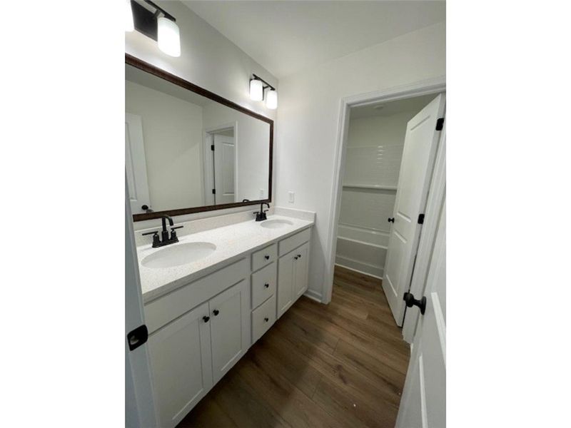 This bathroom offers a large vanity with dual sink