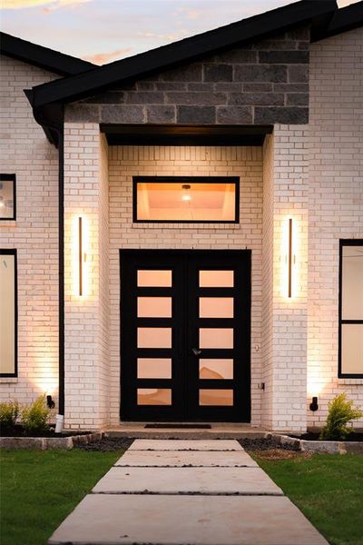 Exterior entry at dusk featuring french doors and brick siding Exterior entry at dusk featuring french doors and brick siding