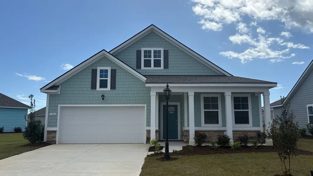 Front exterior of a new home in Brunswick Plantation, Ash, NC, highlighting curb appeal (Image 2). Front exterior of a new home in Brunswick Plantation, Ash, NC, highlighting curb appeal (Image 2).