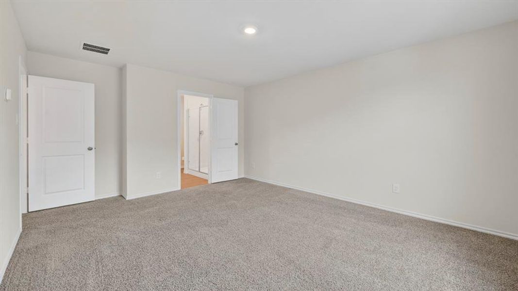 Spacious room featuring neutral carpeting and light-toned walls