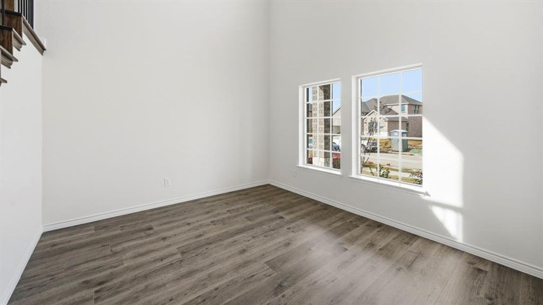 Empty room with dark wood-style floors and a high ceiling