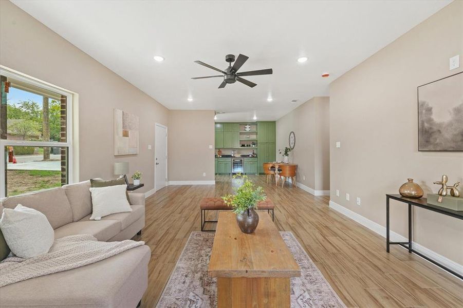 Living room with recessed lighting, light wood-style flooring, a ceiling fan, and wine cooler Living room with recessed lighting, light wood-style flooring, a ceiling fan, and wine cooler