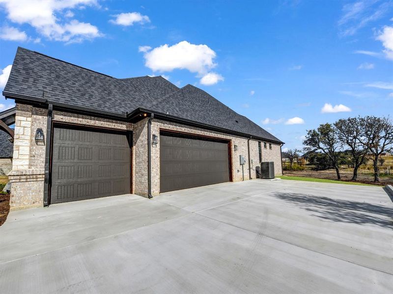 View of property exterior featuring a garage and central air condition unit