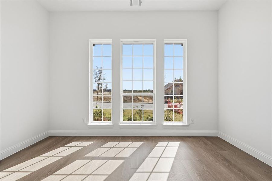 Unfurnished room with healthy amount of natural light and light wood-style floors Unfurnished room with healthy amount of natural light and light wood-style floors