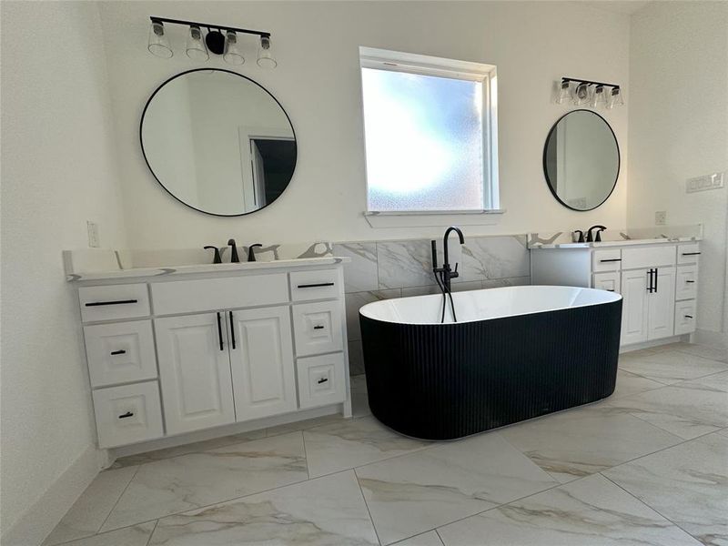 Bathroom featuring a washtub, vanity, and tile walls