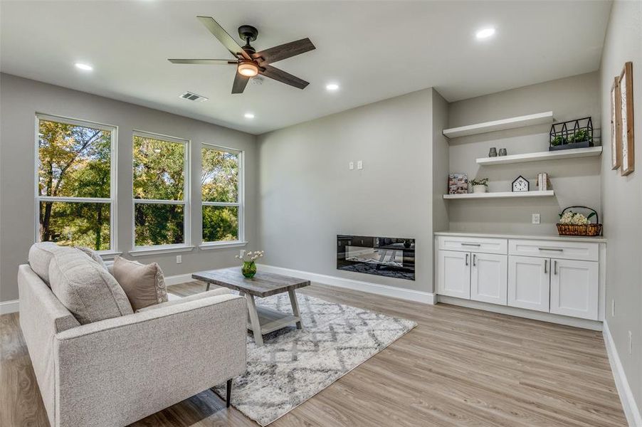 Living area with light wood-style floors, recessed lighting, and a ceiling fan