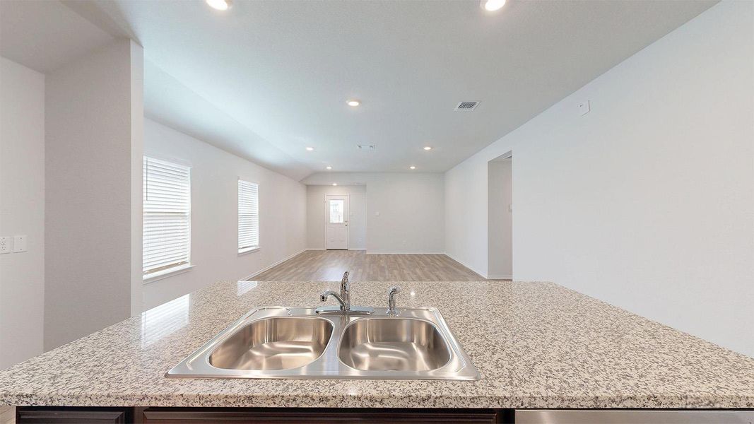 Kitchen with a center island with sink, open floor plan, recessed lighting, and light wood-style floors