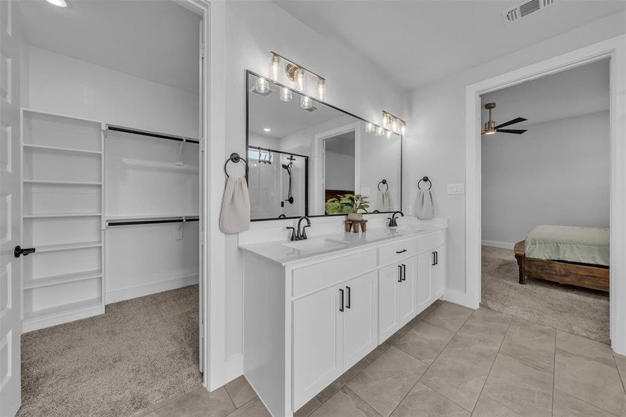 Dual vanity with integrated sinks, white cabinetry, and matte black hardware
