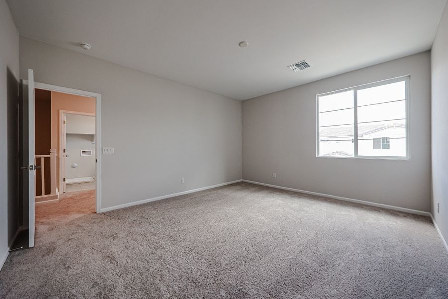 A room with a carpet and a window.