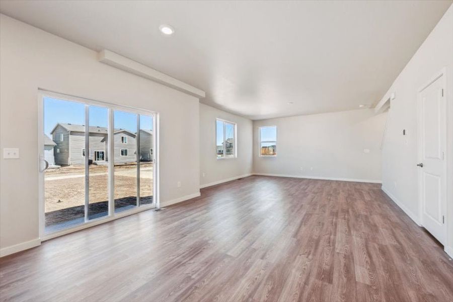 A room with a wood floor and a wood floor with a large window. A room with a wood floor and a wood floor with a large window.