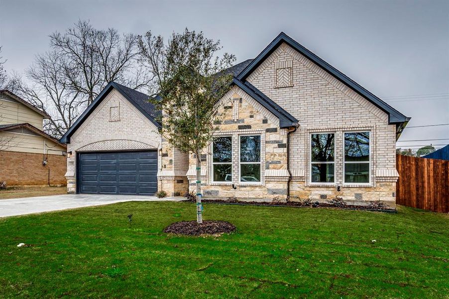 French country home featuring a garage and a front yard