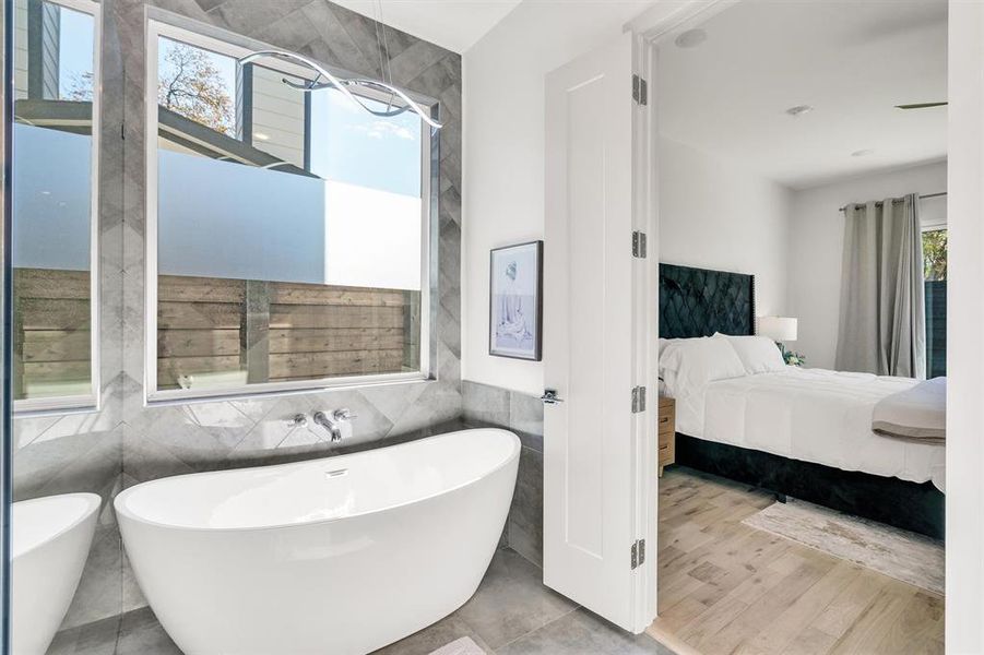 Bathroom featuring tile walls, a tub, and hardwood / wood-style floors