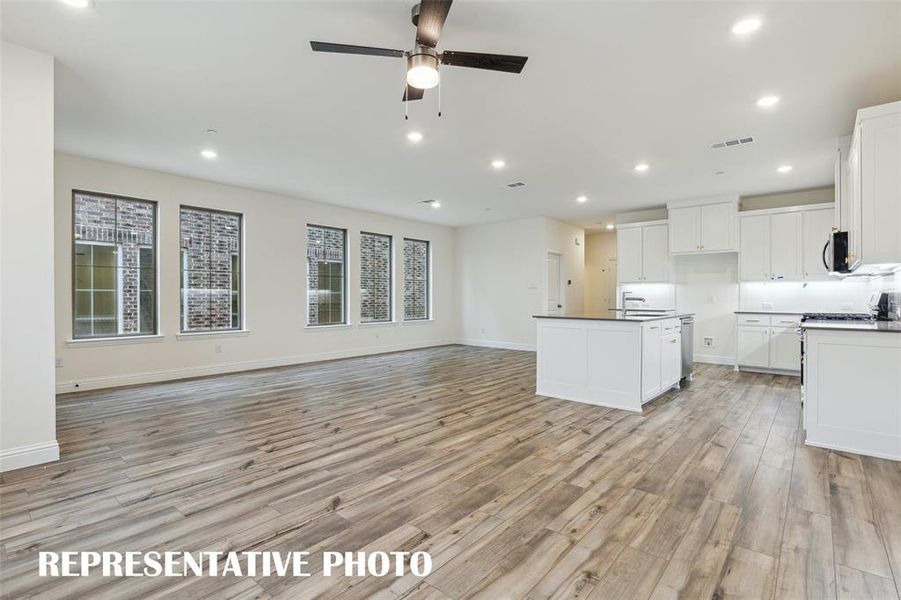 Featuring a wall of windows in the dining-kitchen area, the entire family will love the open and airy feeling this home has to offer!  REPRESENTATIVE PHOTO