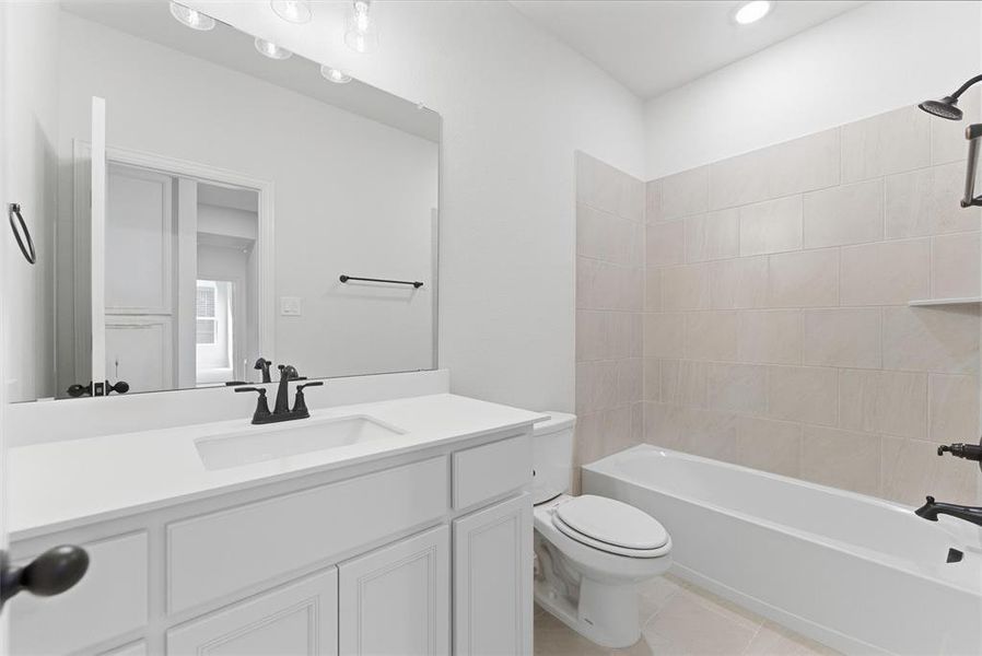 Bathroom with shower / bathtub combination, vanity, and light tile patterned flooring