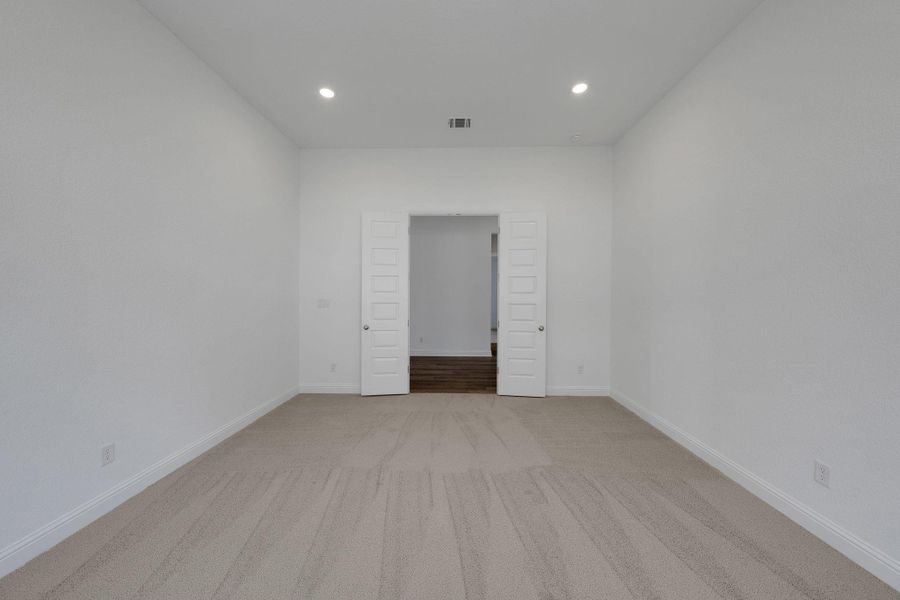 Empty room featuring recessed lighting and light colored carpet