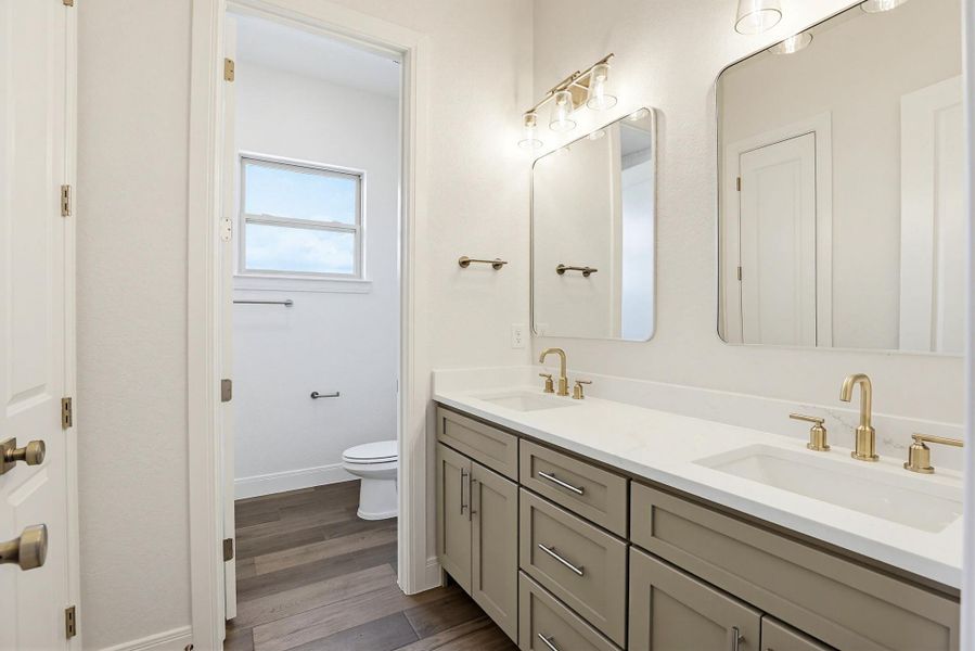Dual vanities with modern fixtures and ample storage elevate this well-appointed bathroom.