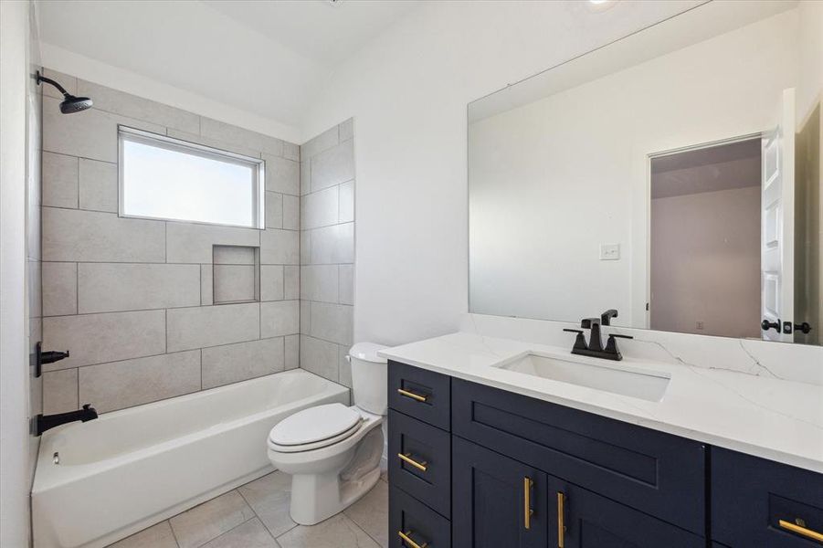 This modern bathroom features sleek tile work and a clean design, offering a refreshing space for your daily routine. The well-lit vanity adds a touch of luxury to this practical space.