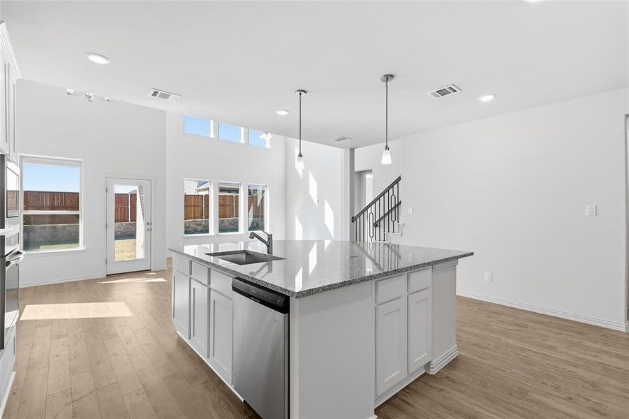 Kitchen featuring white cabinetry, stainless steel appliances, light wood-style flooring, light stone countertops, and recessed lighting