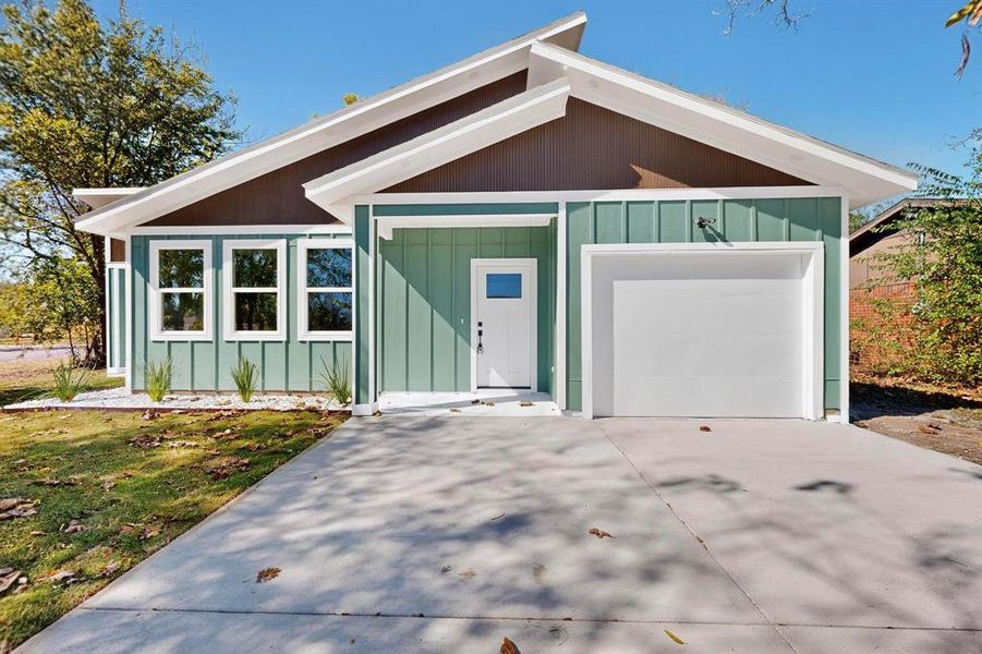 View of front of house featuring driveway, board and batten siding, and an attached garage View of front of house featuring driveway, board and batten siding, and an attached garage