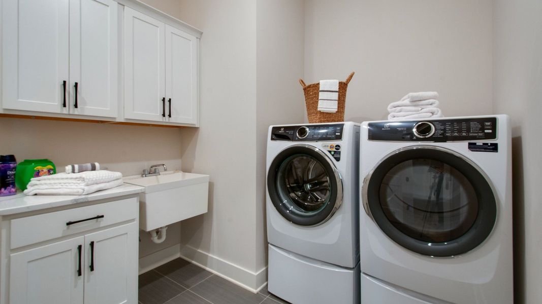 Dedicated laundry room with built-in sink, cabinets, and folding area Dedicated laundry room with built-in sink, cabinets, and folding area