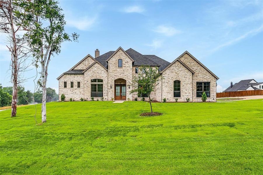 French country style house featuring a front yard