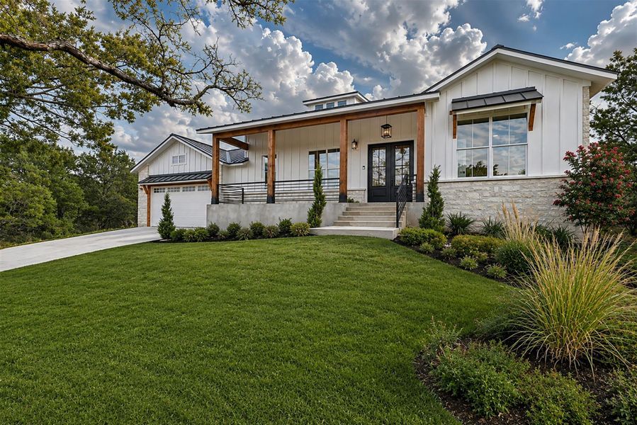 Board and batten siding pairs beautifully with stone accents on this modern exterior. Board and batten siding pairs beautifully with stone accents on this modern exterior.