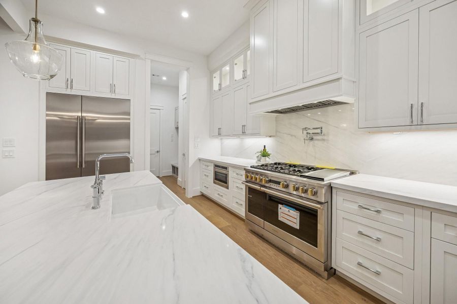 Another view of the Kitchen, with a Large Walk-In Pantry and MUD Area with a Built-In Bench off in the distance.