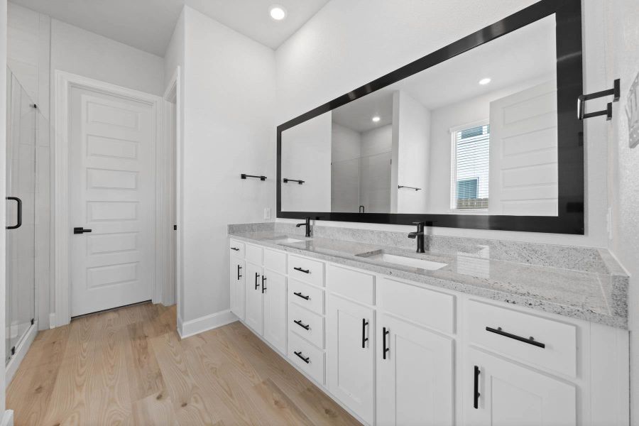 Master bathroom includes granite countertop, elongated mirror, and dual-vanity sinks. Relax in the large soaking tub or enjoy the spacious, standing shower.