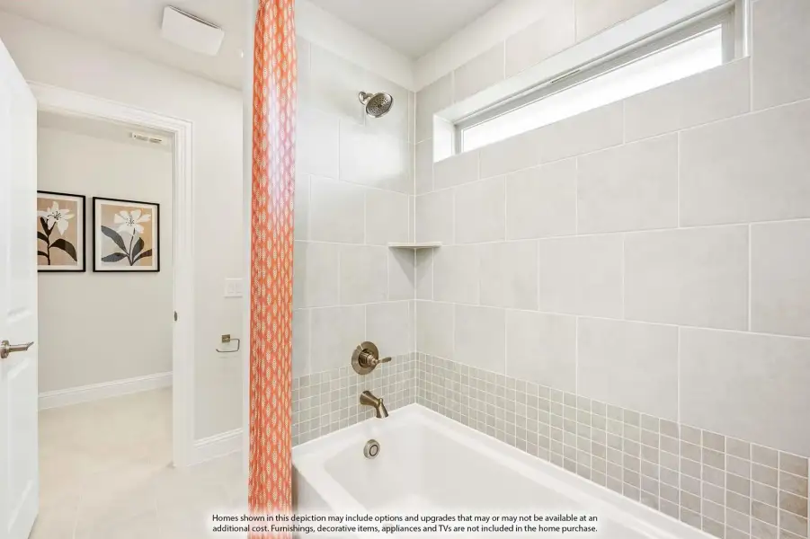 Bathroom with soaking tub, gray tile surround, overhead window, and orange patterned shower curtain