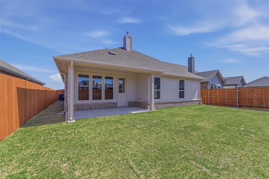 Back of property featuring a fenced backyard, a patio area, a chimney, and a shingled roof