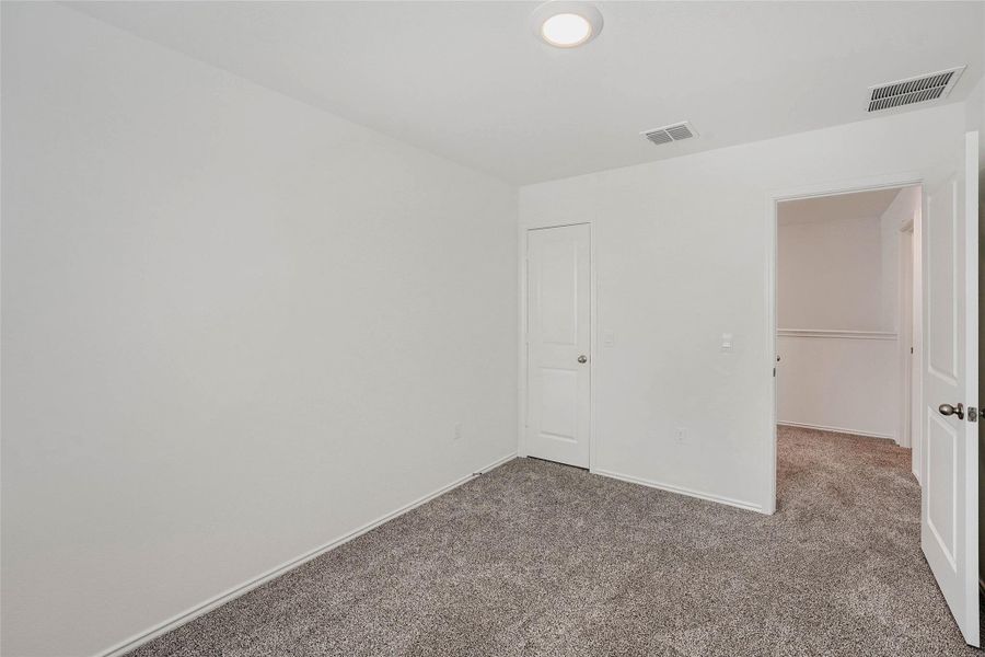 Bedroom #3 featuring plush grey carpeting, a flush-mount ceiling light, and white trim Bedroom #3 featuring plush grey carpeting, a flush-mount ceiling light, and white trim