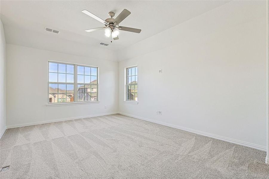 Unfurnished room with light colored carpet and a ceiling fan