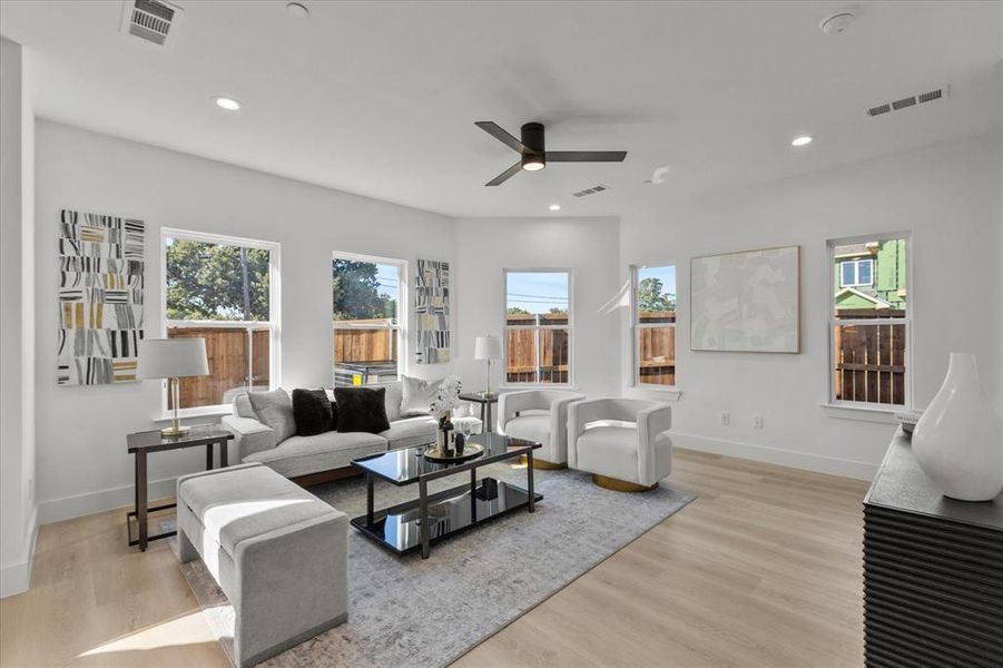 Living room with recessed lighting, light wood-style flooring, and a ceiling fan Living room with recessed lighting, light wood-style flooring, and a ceiling fan