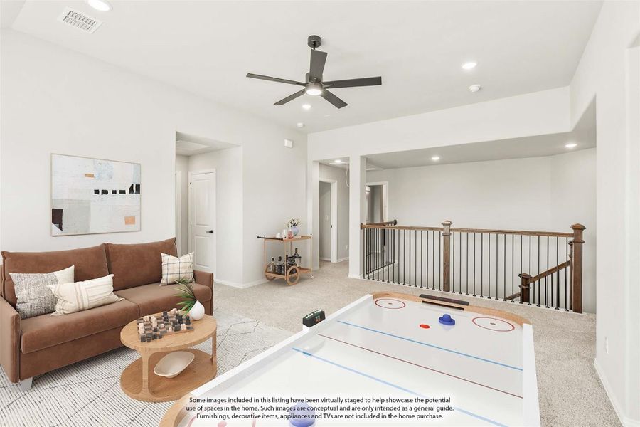 Upstairs loft game room with air hockey table, sofa, ceiling fan, and open staircase railing Upstairs loft game room with air hockey table, sofa, ceiling fan, and open staircase railing