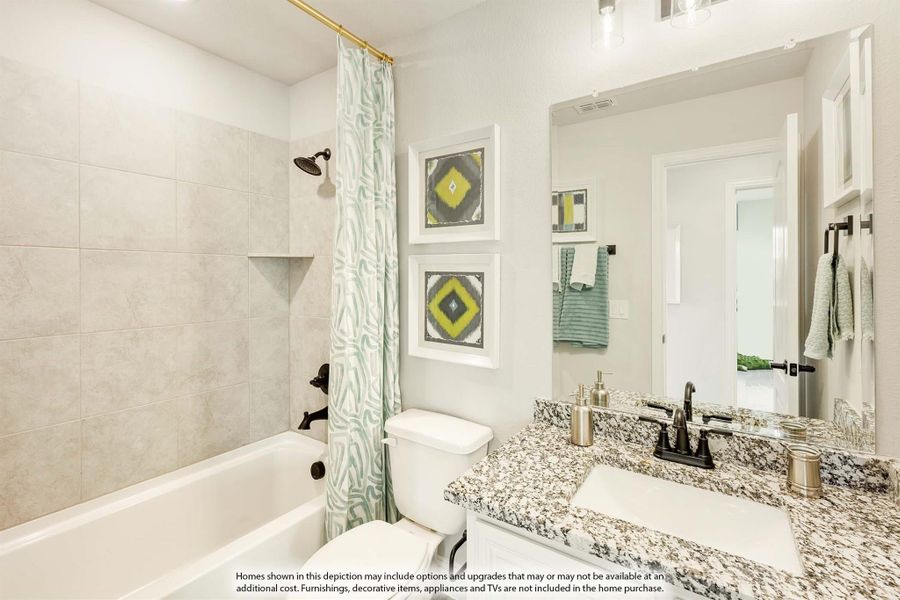 Bathroom with granite countertop vanity, tiled tub and shower combo, and decorative shower curtain Bathroom with granite countertop vanity, tiled tub and shower combo, and decorative shower curtain