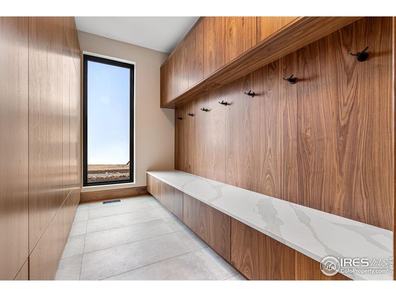 Mudroom: Built-in Pental Quartz slab bench and Shiloh walnut cabinetry with abundant storage solutions.  Architectural Surface Castlestone Tile and Tech Lighting.