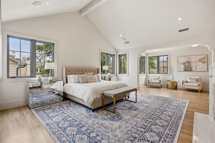 Spacious room featuring vaulted ceilings, light wood-finish flooring, multiple casement windows with dark frames, and recessed lighting Spacious room featuring vaulted ceilings, light wood-finish flooring, multiple casement windows with dark frames, and recessed lighting