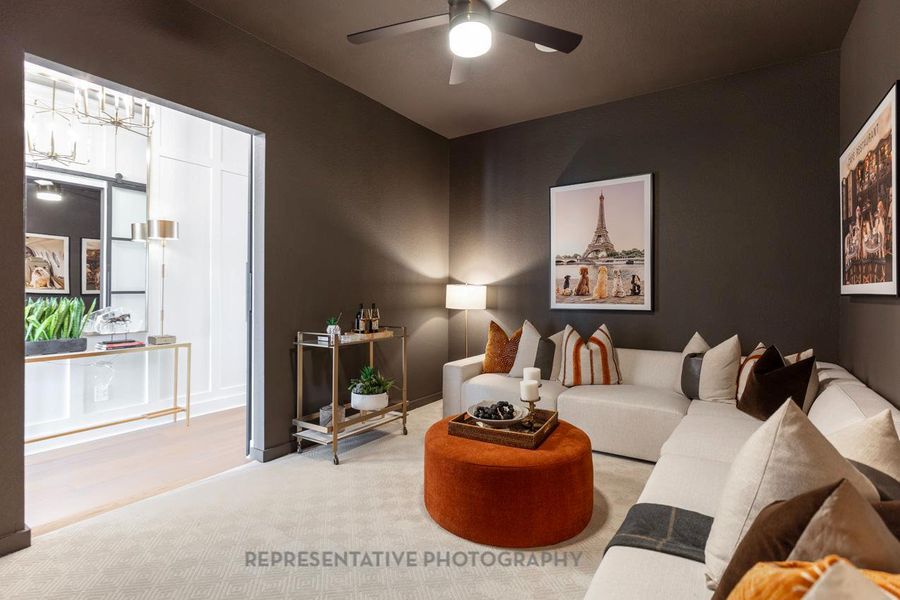 Living room with carpet floors, a ceiling fan, and a chandelier Living room with carpet floors, a ceiling fan, and a chandelier