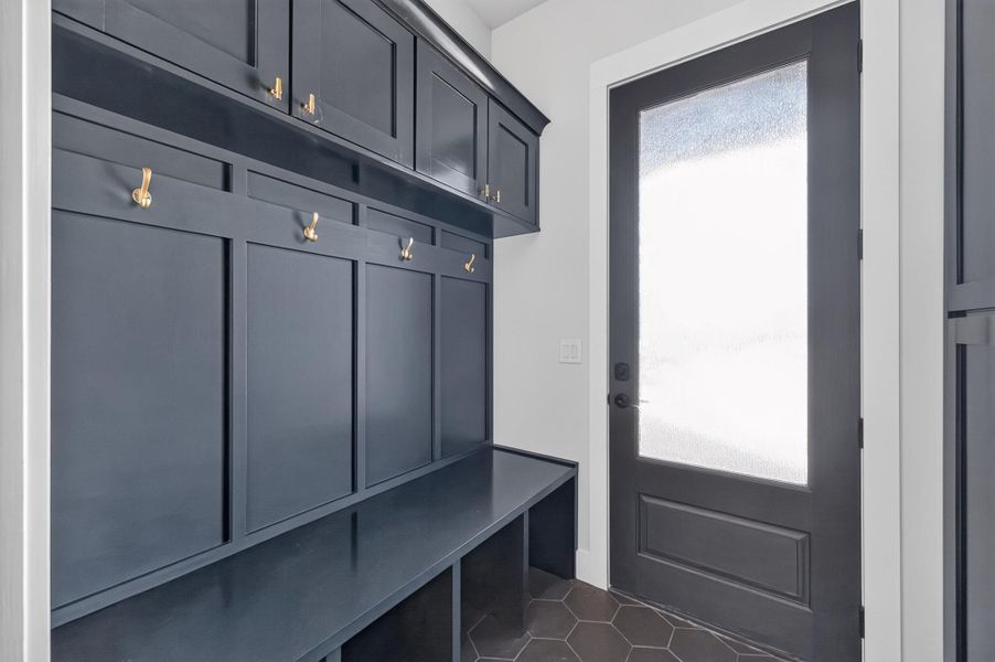Custom cabinetry and built-in bench seating line this functional entry space with tiled flooring.