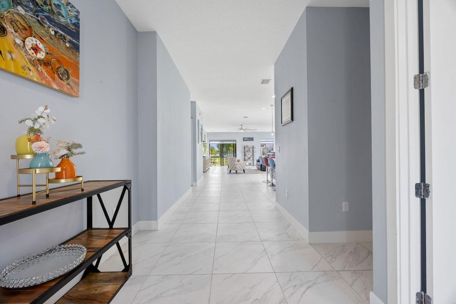 Corridor featuring light marble finish floors and recessed lighting