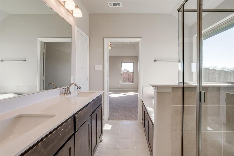 Bathroom with lofted ceiling, tile patterned floors, ceiling fan, separate shower and tub, and vanity Bathroom with lofted ceiling, tile patterned floors, ceiling fan, separate shower and tub, and vanity