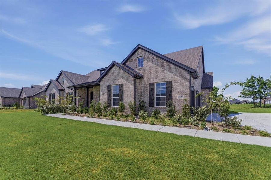 Brick exterior featuring dark gabled roofing and black decorative shutters Brick exterior featuring dark gabled roofing and black decorative shutters