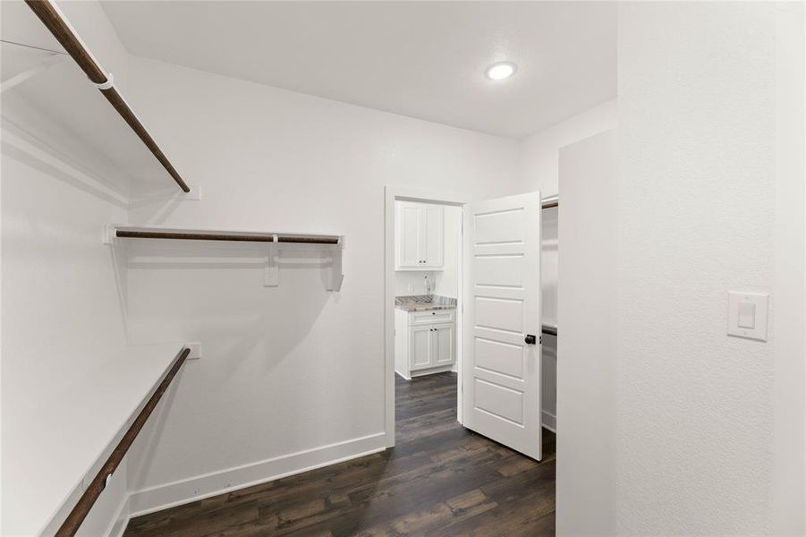 Walk in closet with dark wood-style floors Walk in closet with dark wood-style floors